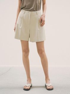 This is a refined and minimal pants by Siyazu that is made out of high quality and sturdy material. With classic mood of the design and feminine look, you can style it for your refined and casual daily outfit.- Single tuck detail- Comfortable and soft touch of fabric- Natural sea shell buttons- Clean logo embroidery detail Chic Neutral Cotton Shorts, Chic High-waisted Shorts In Solid Color, Khaki Solid Color Bottoms For Workwear, Chic Solid Color Short Bottoms, Chic High-waisted Solid Color Shorts, Khaki Bottoms For Workwear, Classic Relaxed Fit Bottoms For Day Out, Classic Cotton Bottoms For Day Out, High-waisted Khaki Shorts For Work