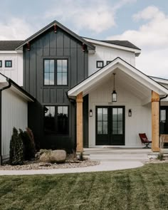 a white and black house with wooden pillars