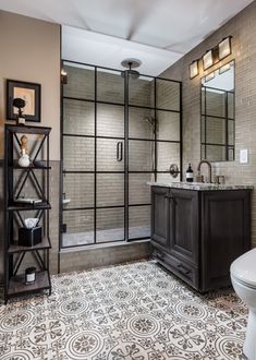 a bathroom with a toilet, sink and shower in it's stall area next to a tiled floor