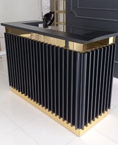 a black and gold counter top in the middle of a white tile floored room