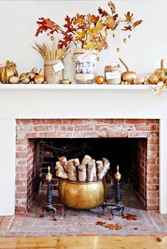 the fireplace is decorated with fall leaves and pumpkins