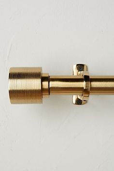 a close up of a gold colored curtain rod