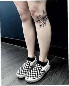 a woman's legs with black and white checkered shoes