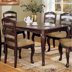 a dining room table with six chairs and a rug