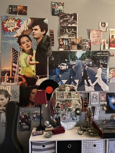 a room filled with lots of posters and pictures on the wall next to a dresser