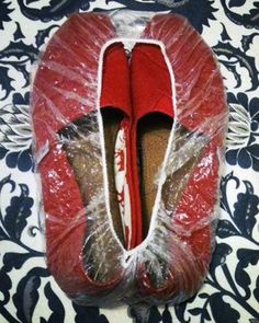 a pair of red shoes sitting on top of a bed