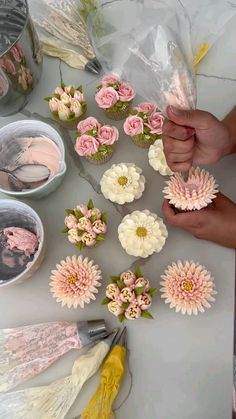 someone is decorating cupcakes with pink and white flowers