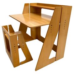 a wooden desk and chair sitting next to each other on a white surface with no one in it