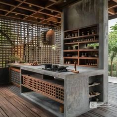 an outdoor kitchen with wooden flooring and built in shelving