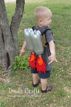 a little boy standing in front of a tree wearing a backpack and holding two balloons