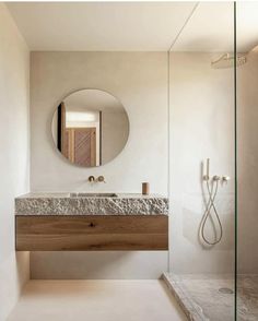 a bathroom with a sink, mirror and shower stall in it's center area