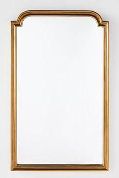 a gold framed mirror hanging on the wall