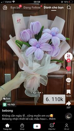 a person holding a bunch of purple flowers