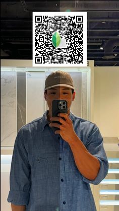 a man taking a selfie in front of a qr - code sticker