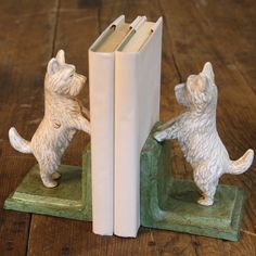 two bookends made out of books on top of a wooden table with a dog figurine next to them