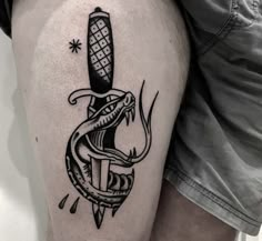 a man with a tattoo on his leg has a snake holding a knife in it's mouth