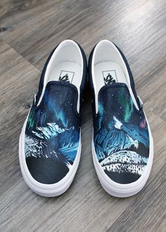 I hand painted these new, never worn, Vans Classic Slip-on shoes featuring the aurora borealis, or northern lights, dancing in the sky above snow capped mountains and silhouetted trees. This is an original painting, completed with heat set shoe paint and sealed with protective spray. I paint all of my custom pieces with love and attention to detail. These shoes have navy panels around the sides and back of the shoes. They are a men's size 7.5 and women's size 9. Ready to ship internationally in Painted Vans Slip On, Painted Vans Shoes, Custom Painted Vans, Dancing In The Sky, Hand Painted Vans, Custom Vans Shoes, Snow Capped Mountains, Vans Classic Slip, Painted Vans