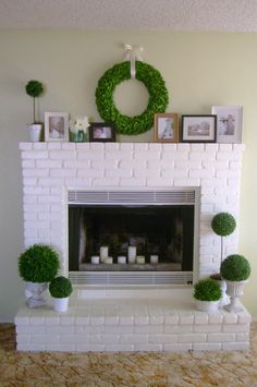 a living room with a white brick fireplace and potted plants on the mantel