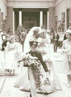 an old black and white photo of a bride carrying her groom