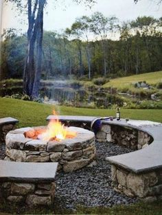 an outdoor fire pit with benches around it