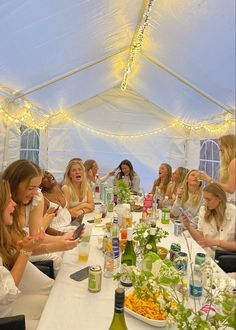 a group of women sitting around a table with food and drinks