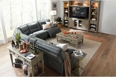 a living room filled with furniture and a flat screen tv on top of a wooden table