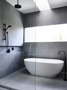 a white bath tub sitting in a bathroom next to a window