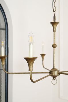 a chandelier with three candles hanging from it