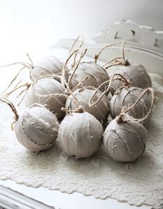 some balls are sitting on a doily with twine and burlap around them