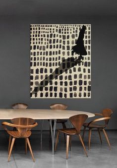 a dining room table with chairs and a painting on the wall