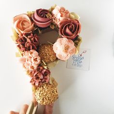 a hand holding a doughnut decorated with flowers