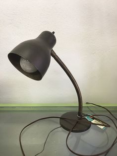 a desk lamp sitting on top of a table next to a charger and power cord