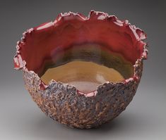 a red and brown bowl sitting on top of a table