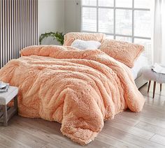 a bed with an orange comforter and pillows