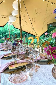 a table set with place settings and umbrellas for an outdoor dinner or party in the garden