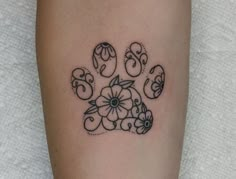 a dog paw tattoo with flowers on it