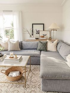 a living room filled with lots of furniture and pillows on top of a rug next to a window