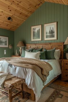 a bedroom with green walls and wood ceilinging, two pictures on the wall above the bed