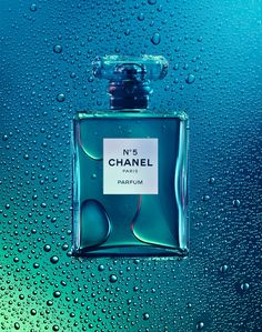 a bottle of chanel perfume sitting on top of a blue and green tablecloth