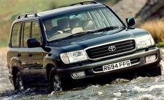 a black suv is driving through some water