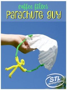 a hand holding a tissue paper bag with the words coffee filter parachute guy on it