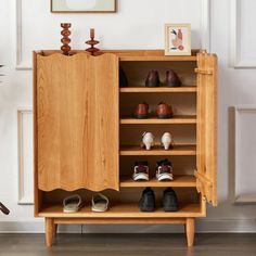 a wooden cabinet with shoes in it