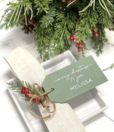 a place setting with pine cones and greenery