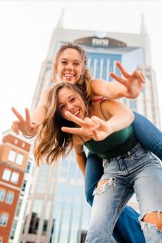 two girls are playing in the street with their hands out and one girl is wearing ripped jeans