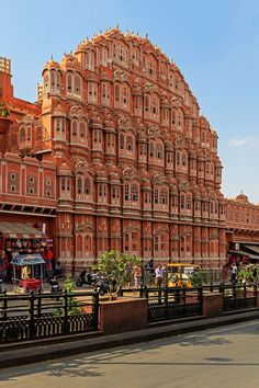 an ornate building with many windows and balconies on the top floor, in india