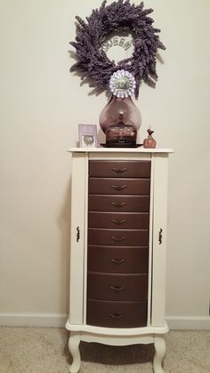 a white dresser with drawers and a clock on top