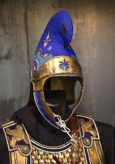 a blue and gold helmet on top of a mannequin's head in front of a wall