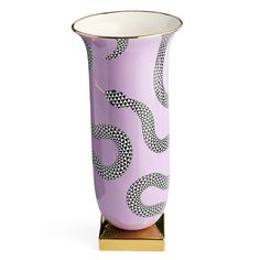 a purple vase with black and white designs on the outside, sitting on a gold stand