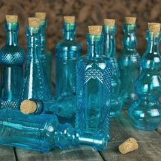 there are many blue glass bottles with corks on the table