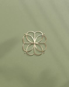 a metal flower on a green surface with the center cut out to look like it's floating